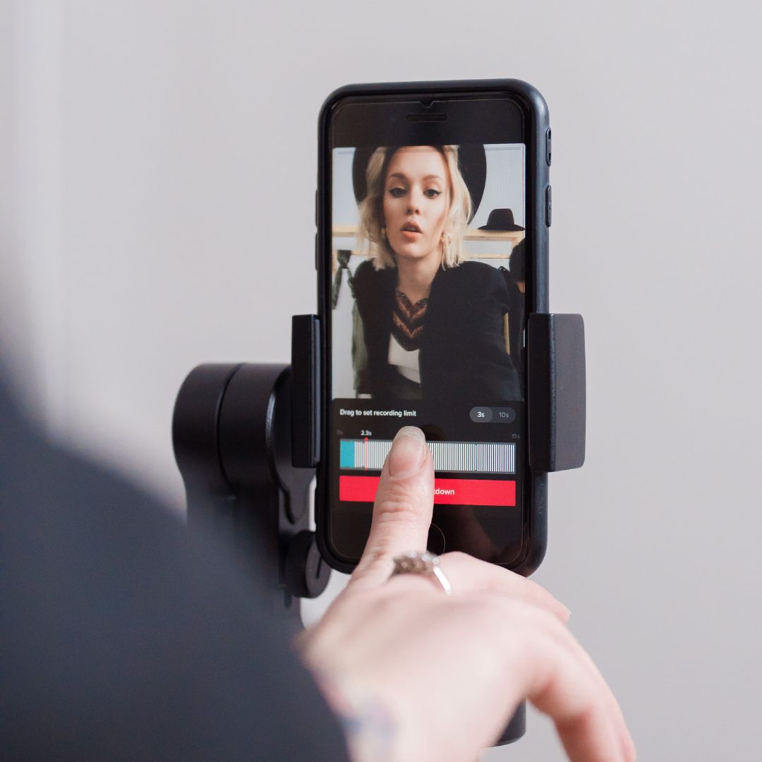 Person touching a phone that's on a tripod