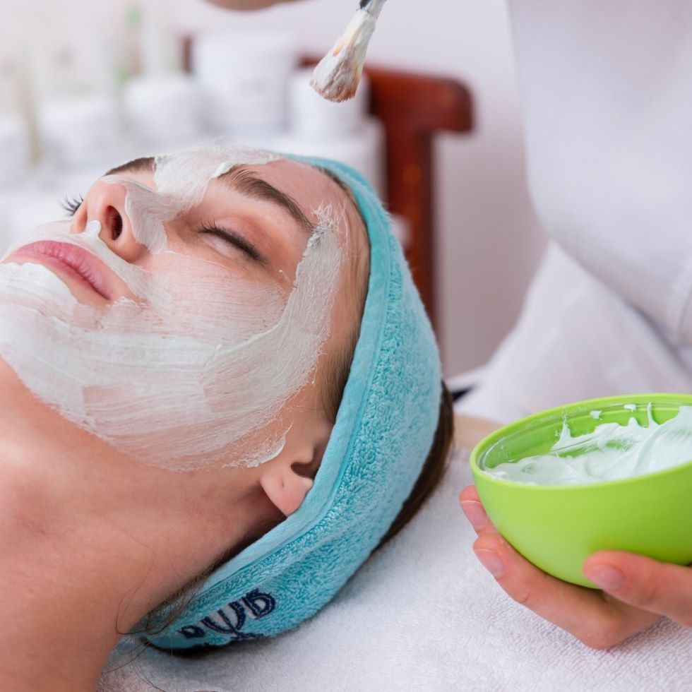 Person applying facial mask to customer